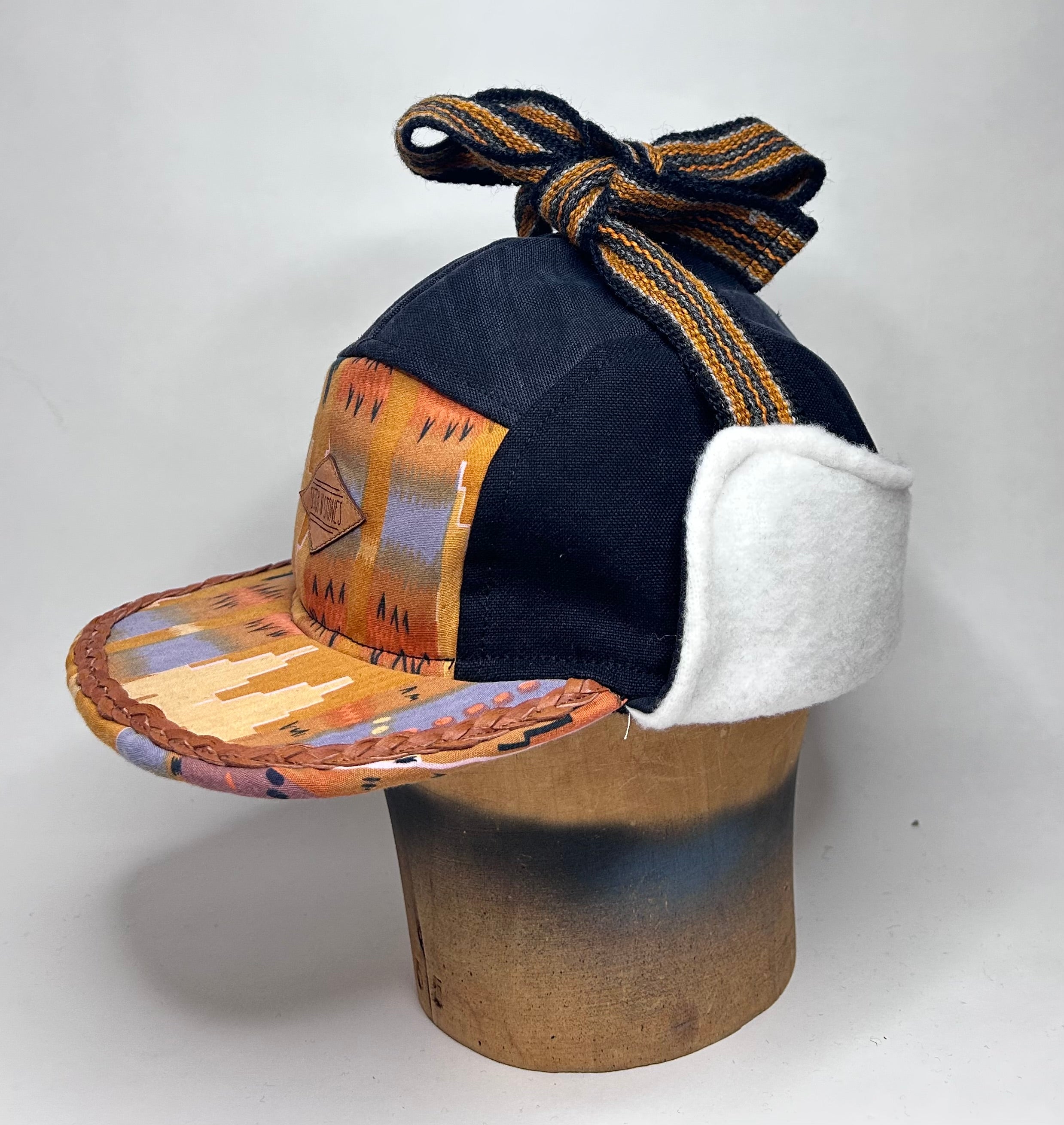 Vinterkeps 58-59cm - svart bomullscanvas, orangemönstrat