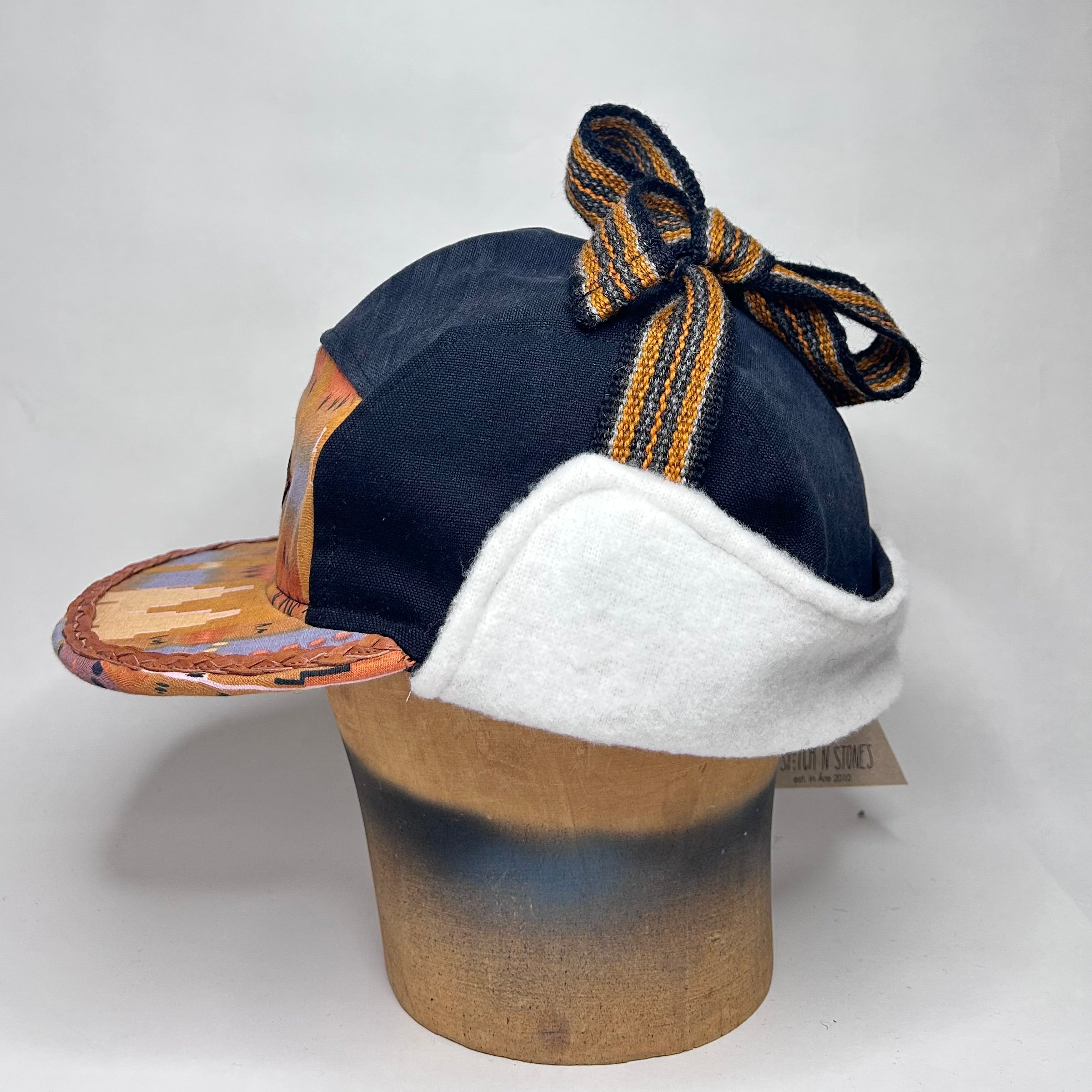 Vinterkeps 58-59cm - svart bomullscanvas, orangemönstrat